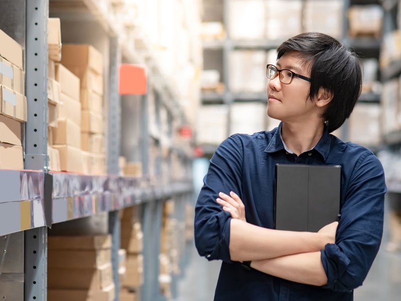 A man looking at the logistics stuff inside the warehouse