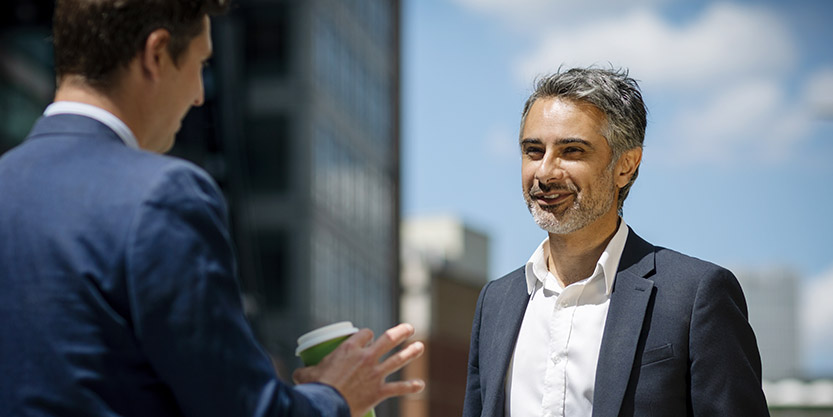 Two men speaking at outside