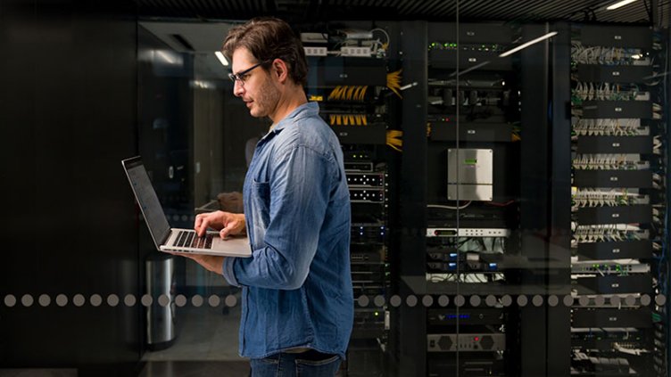 Man walking inside a room with laptop