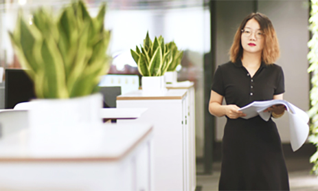 Smart businesswoman standing in modern office and holding papers