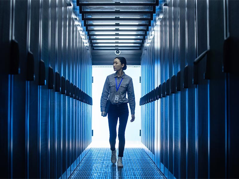 A lady with a lanyard walking through a data centre facility