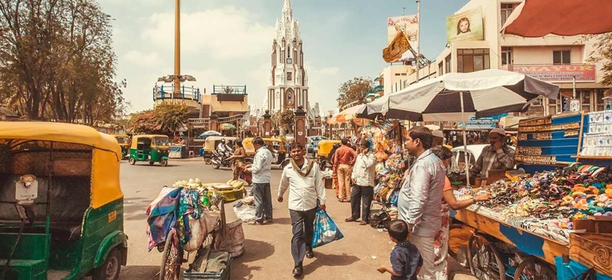 Crowd of people on the street with vehicles and shopping centres