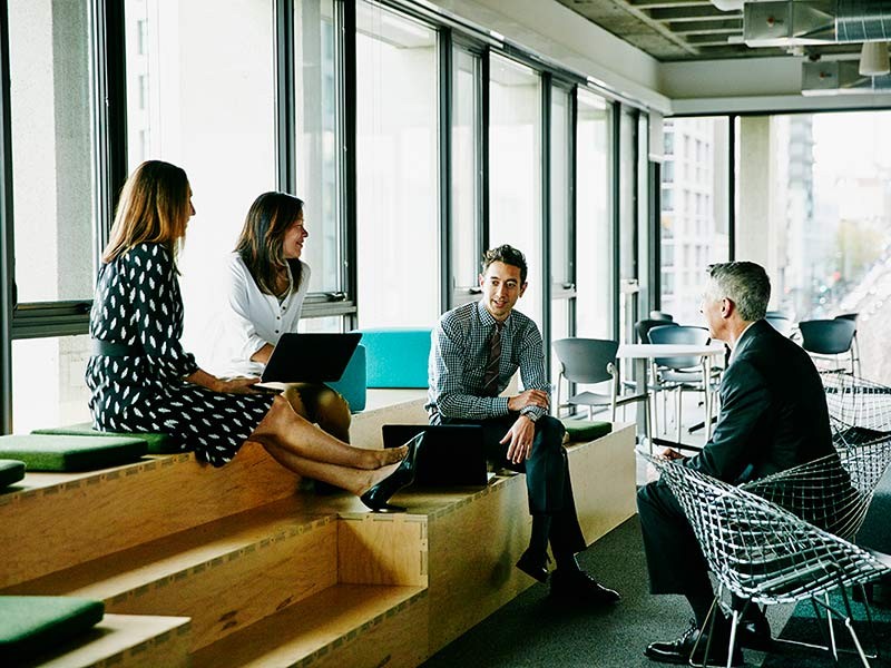 Colleagues meeting and collaborating in an informal office gathering space