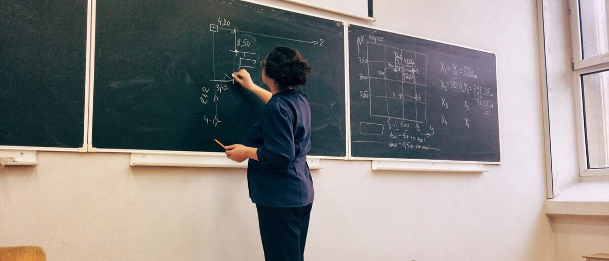 Teacher teaches the class by making a graph in the blackboard